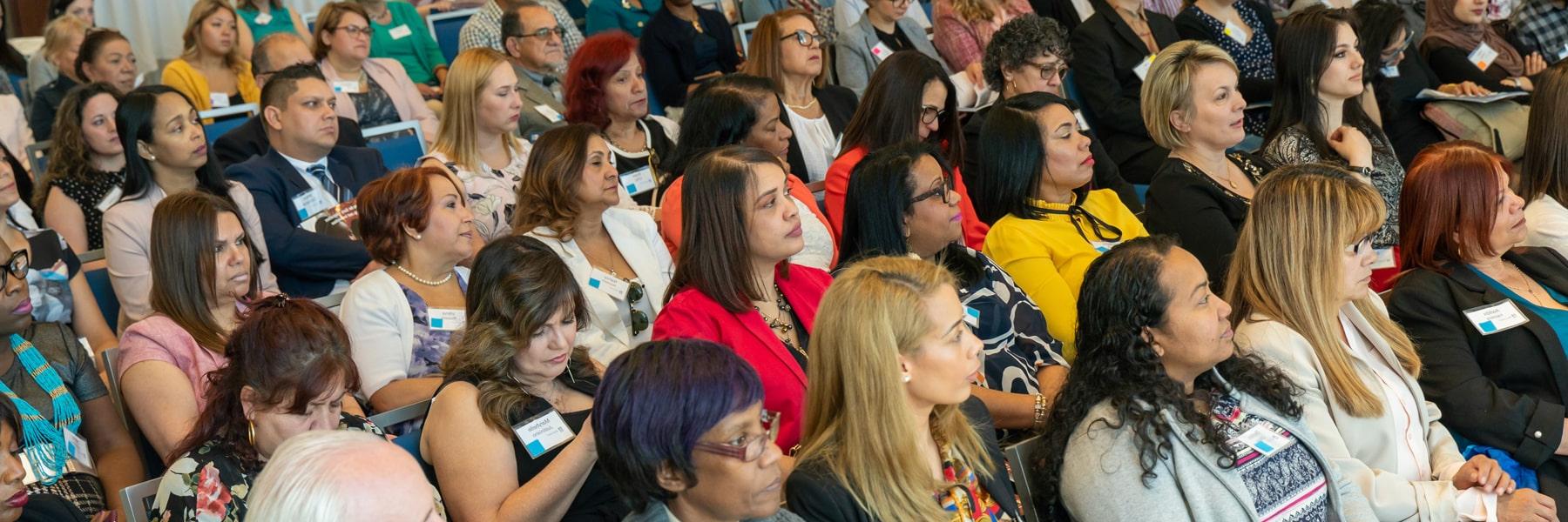 diverse audience in age, gender and ethnicity sitting at a conference